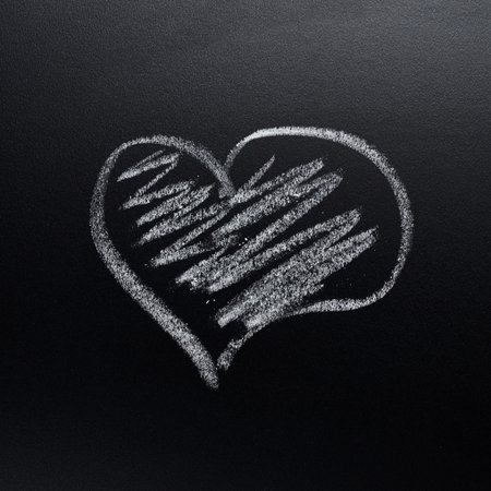Heart symbol drawn with the chalk on the black blackboard