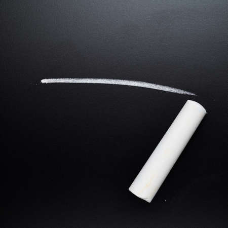 Drawn on the black blackboard white line next to a piece of chalkの写真素材