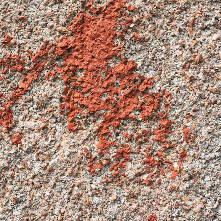 Fragment of an old concrete wall covered with the red paint as a grungy background textureの写真素材