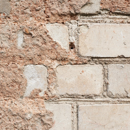 Fragment of an old white brick wall covered with the cement as a grungy background texture...