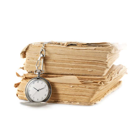 Old silver pocket watch lying over the pile of old yellow books, composition isolated over the white backgroundの写真素材