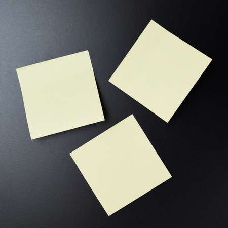 Blackboard covered with three copyspace empty sticky paper notesの写真素材