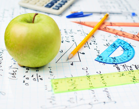 Studying math back to school composition of the green apple and some stationery office supplies...