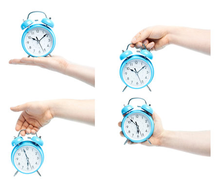 Caucasian male hand holding a blue alarm clock, high-key light composition isolated over the white...