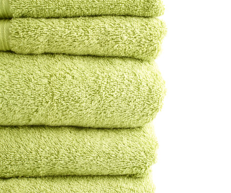 Composition of multiple green terry cloth bath towels in a pile against the white backgroundの写真素材