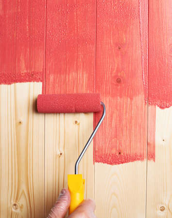 Process of painting the wood boards with the red paint rollerの写真素材