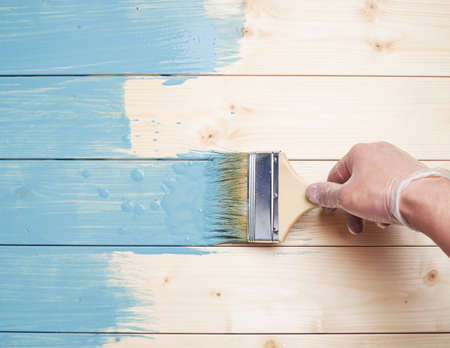 Process of painting the pine wood boards with the brush and the blue paintの写真素材