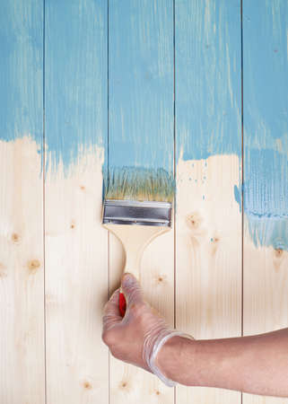 Process of painting the pine wood boards with the brush and the blue paintの写真素材