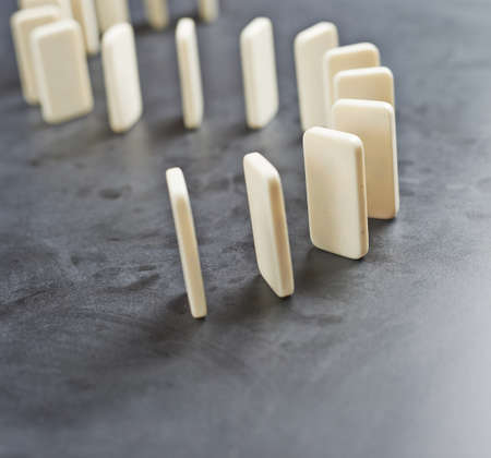 Domino\'s effect composition of a multiple domino bones placed in a row over the dark gray surfaceの写真素材