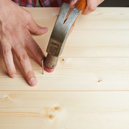 Missing the nail and hitting finger with the hammer compositionの写真素材