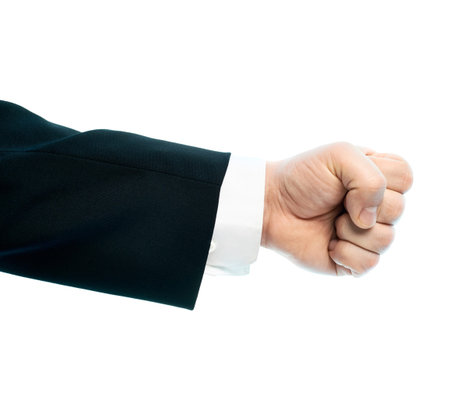 Dressed in a business suit caucasian male hand gesture of a clenched fist, high-key light composition isolated over the white backgroundの写真素材