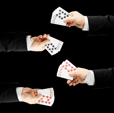Caucasian male hand in a business suit, holding playing cards including ones in the sleeve, low-key...
