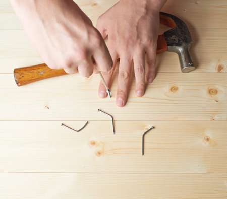 Screwing the screw after failing to hammer a nail to the wooden boards compositionの写真素材