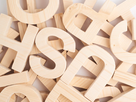 Surface covered with multiple wooden letters as a background composition