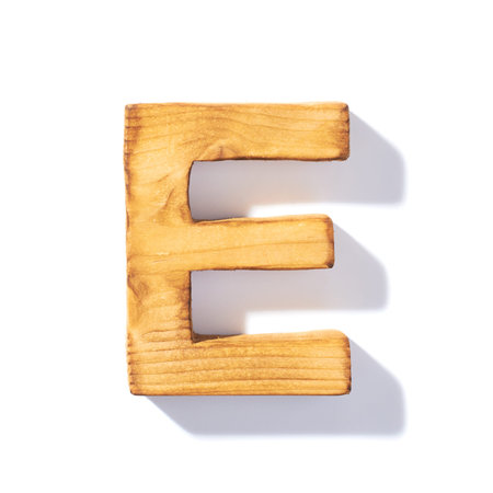 Single brown wooden E letter with 45 degree long shadow as a real life flat design font, isolated over the white backgroundの写真素材
