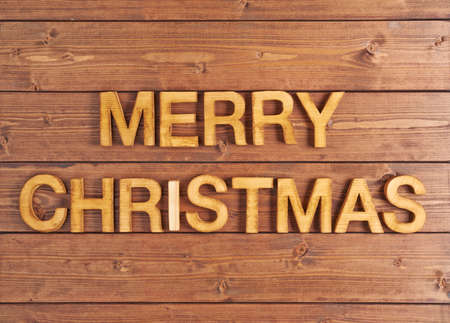 Merry Christmas composition of the wooden letters over the wooden boards surfaceの写真素材