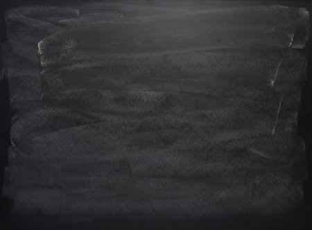 Black board with the traces of chalk over its surface as a background texture
