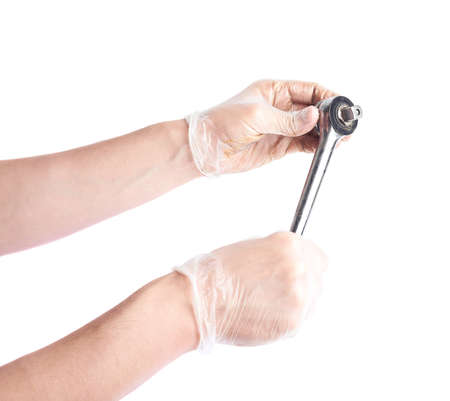 Workers caucasian male hands in a dirty rubber gloves holding a hex box spanner tool, composition isolated over the white backgroundの写真素材