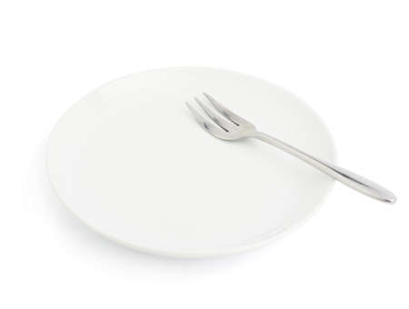 Knife and fork over the empty white ceramic plate isolated over the white backgroundの写真素材