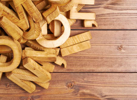 Pile of wooden letters over the wooden surface as a typography background compositionの写真素材