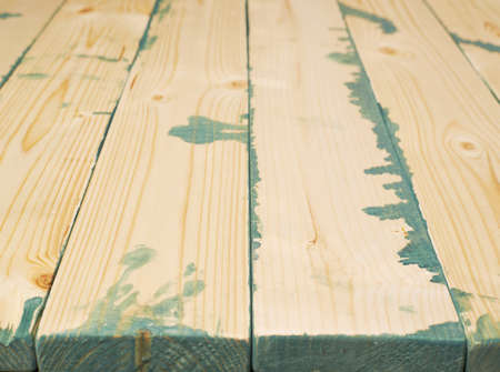 Surface covered with multiple pine wood boards with the paint stains and leaks in the gaps, as an abstract background composition with a shallow depth of fieldの写真素材