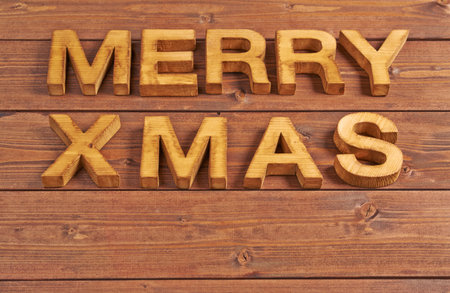 Merry Xmas composition of the wooden letters over the wooden boards surfaceの写真素材