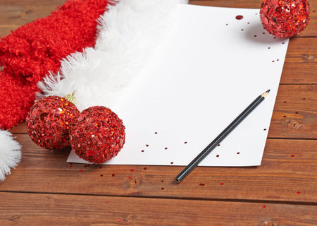 Letter to the Santa Claus composition of the copyspace blank sheet of paper next to multiple Christmas decorations over the wooden surfaceの写真素材