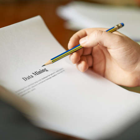 Data mining definition as a shallow depth of field close-up composition of a man in a business suit working with the textの写真素材