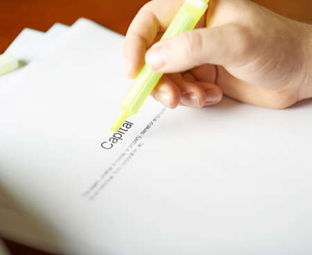 Capital definition as a shallow depth of field close-up composition of a man in a business suit working with the textの写真素材