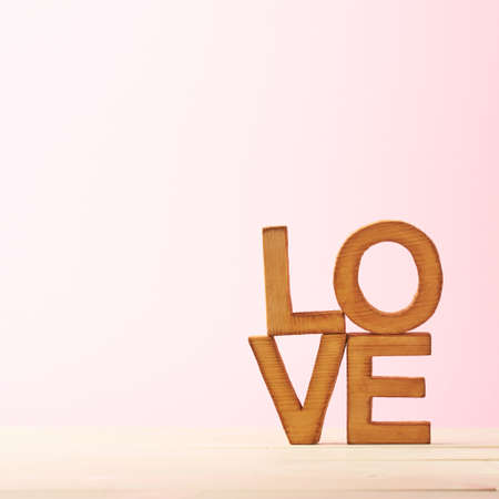 Love composition of wooden block letters agains the pink backgroundの写真素材