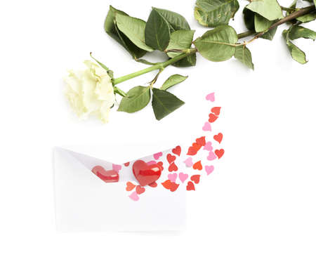 White rose and envelope filled with hearts as a romantic love letter, composition isolated over the white backgroundの写真素材