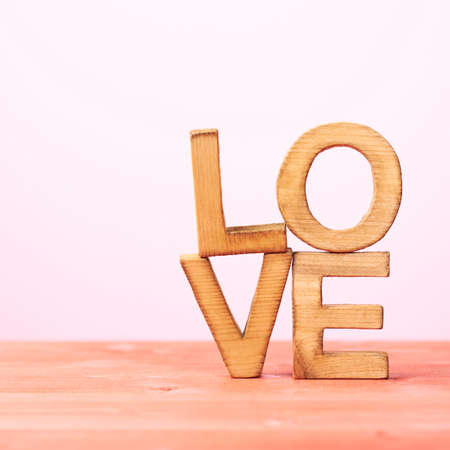 Love composition of wooden block letters agains the pink backgroundの写真素材