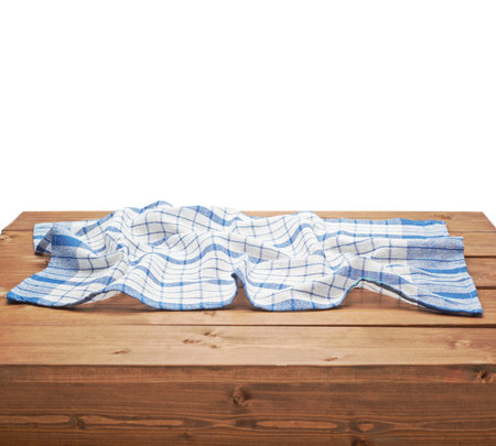 Blue tablecloth or towel over the surface of a brown wooden table, composition isolated over the...