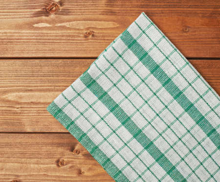Green tablecloth or towel over the surface of a brown wooden tableの写真素材