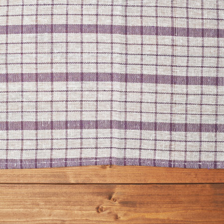 Violet tablecloth or towel over the surface of a brown wooden table