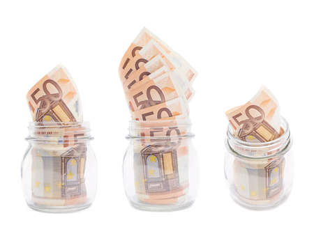 Multiple fifty euro bank notes in a glass jar isolated over the white background, set of three different foreshorteningsの写真素材