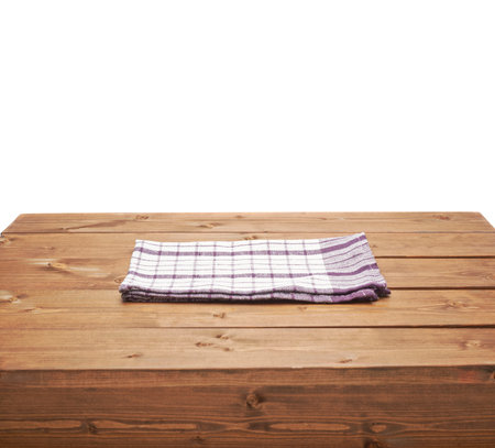Violet tablecloth or towel over the surface of a brown wooden table, composition isolated over the white backgroundの写真素材