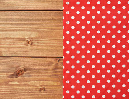Red polka dot tablecloth or towel over the surface of a brown wooden tableの写真素材