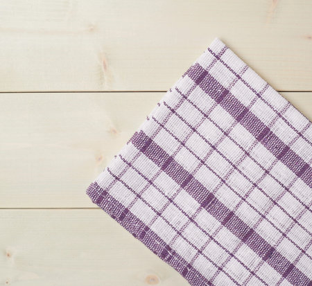 Violet squared tablecloth or towel over the surface of a wooden tableの写真素材