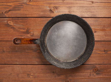 Cooking composition of the old cooking pan over the wooden tables surfaceの写真素材