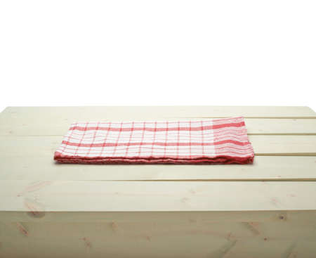 Red tablecloth or towel over the surface of a wooden table, composition isolated over the white の写真素材