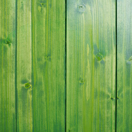 Bright green paint coated wooden pine boards lying in a row as a close-up compositionの写真素材