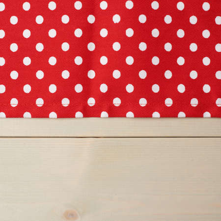 Red polka dot tablecloth or towel over the surface of a wooden tableの写真素材