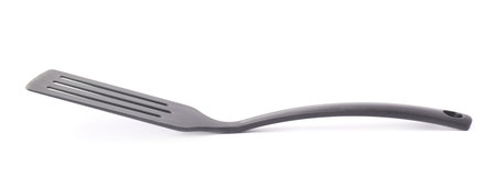 Used black plastic cooking kitchen spatula isolated over the white backgroundの写真素材