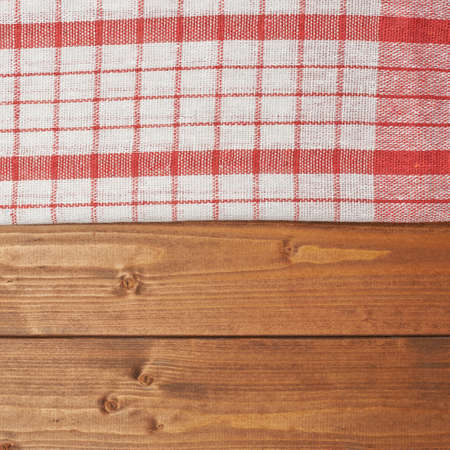 Red tablecloth or towel over the surface of a brown wooden tableの写真素材