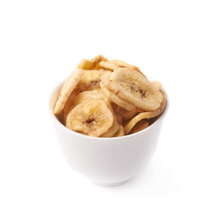Small white ceramic bowl filled with the dried banana slices, composition isolated over the white backgroundの写真素材