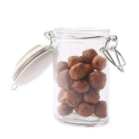 Glass jar filled with hazelnuts isolated over the white backgroundの写真素材