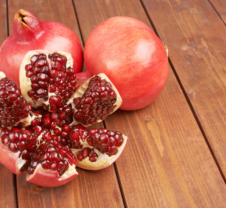 Pomegranate Punica granatum fruit composition placed over the wooden boards surface