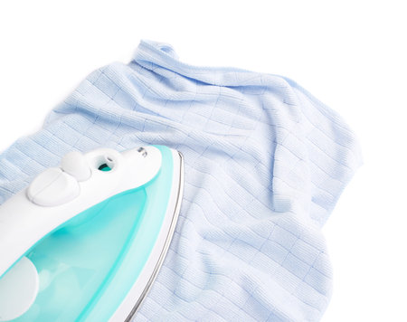 Green iron with blue cloth isolated on a white background, housework, laundry and housekeeping conceptの写真素材