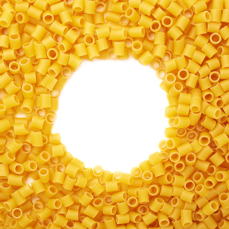 Round frame made of dry ditalini yellow pasta over isolated white backgroundの写真素材
